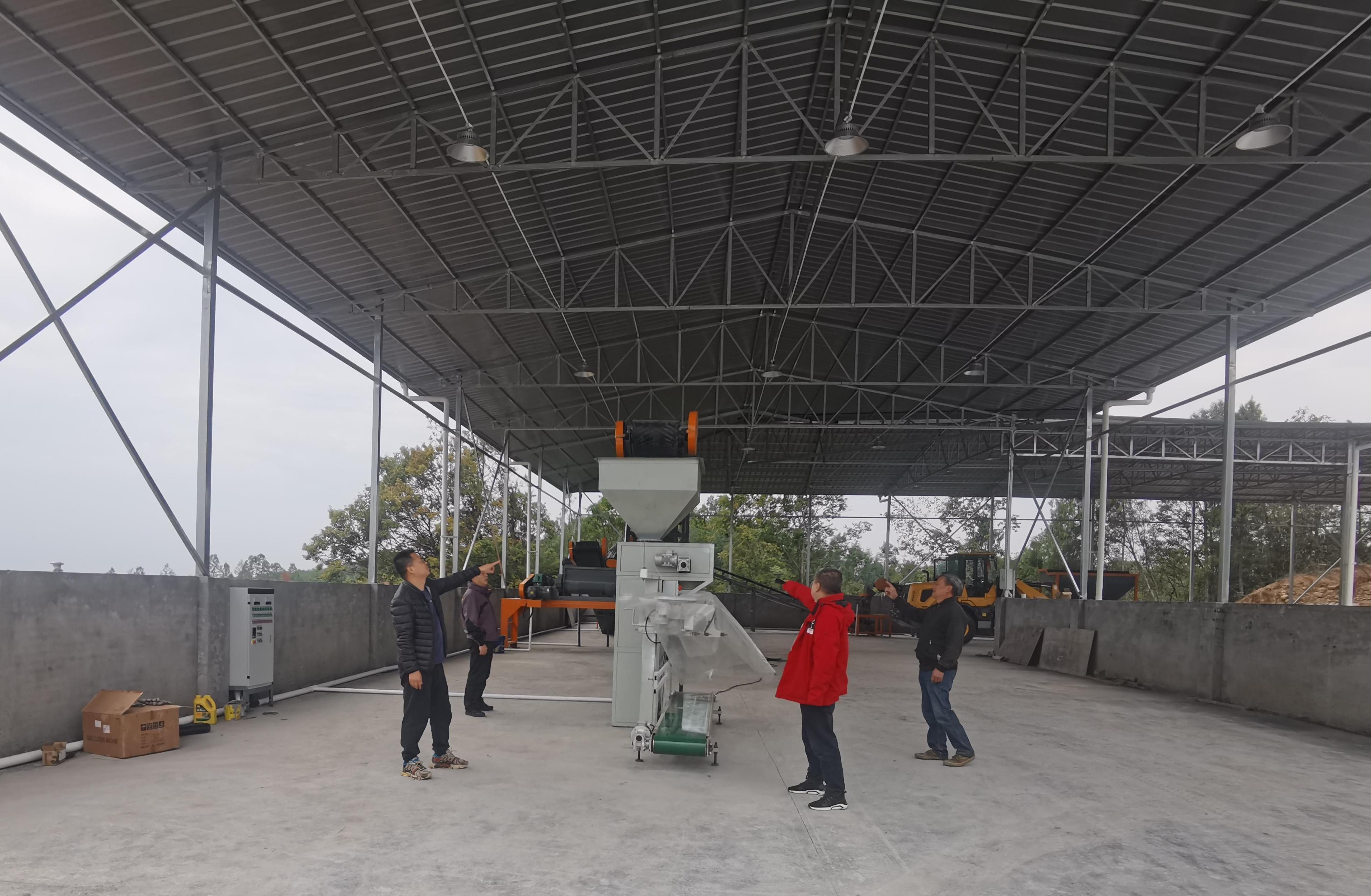 李杰超（左一）與村社干部、駐村隊員查看有機肥廠設(shè)備采購情況